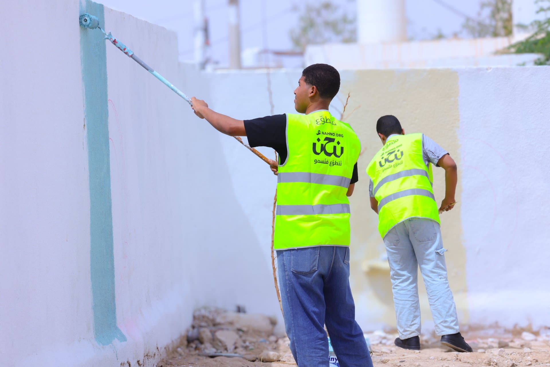 شباب يتطوعون بدهن الجداريات